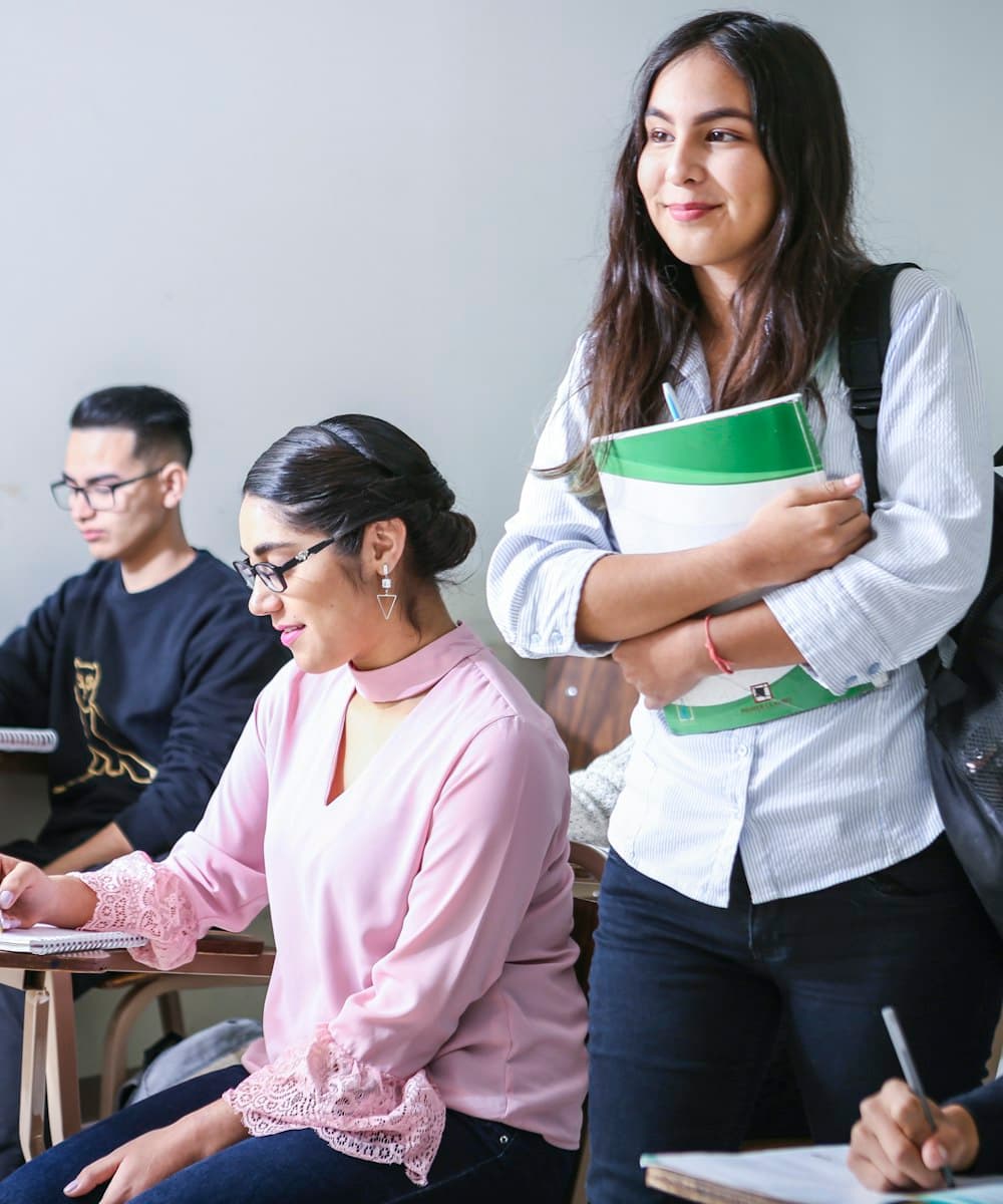 Students holding notebooks and folders between classes